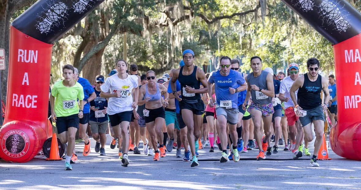 Runners crossing the start line through the festive arch